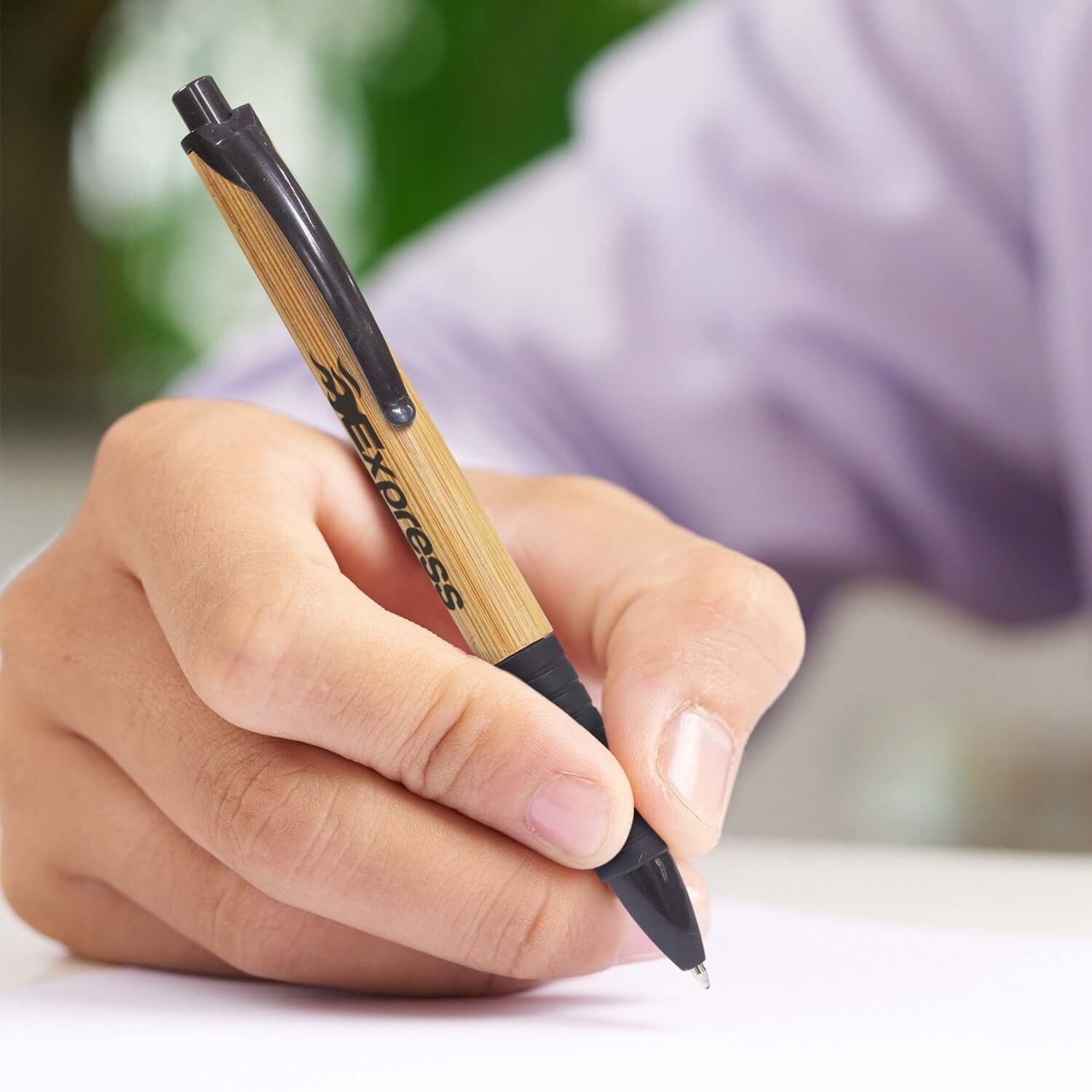 Person holding a Habitat Pen with a bamboo barrel, ideal for corporate gift and eco-friendly writing.