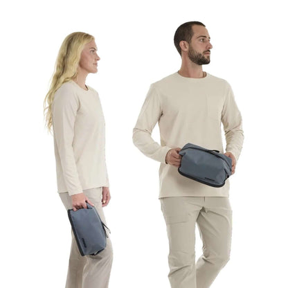 Thule Aion Toiletry Bag held by a man and woman, showcasing its modern design and functionality.