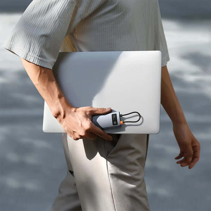 Person holding a laptop with Baseus Joystar 7 in 1 USB-C Hub, perfect for corporate gift and multitasking.