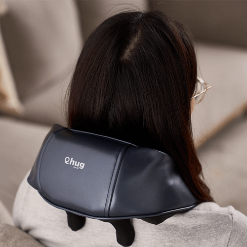 Woman using OTO Q Hug massager for neck and shoulder relaxation, perfect as a corporate gift.