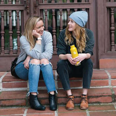 Klean Kanteen Insulated Stainless Steel Classic Bottle with Loop Cap being enjoyed by two friends outdoors.
