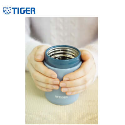 Person holding the Tiger Wide Mouth Stainless Steel Bottle MCA-C, showcasing its elegant design and functionality.