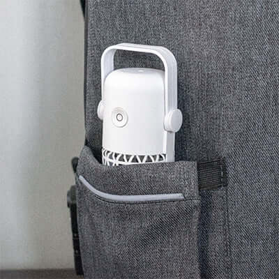 BrandCharger Portable UV Germicidal Lamp nestled in a pocket of a grey backpack, showcasing its portability.