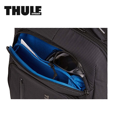 Thule Crossover 2 20L Laptop Backpack showing secure compartment with blue lining and sunglasses inside.