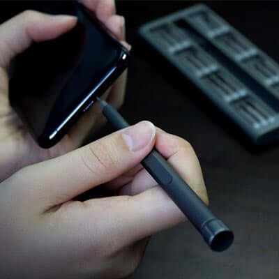 User utilizing the BrandCharger Everyday Kit to open a mobile device with precision during a repair task.