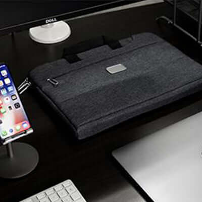 BrandCharger Specter high quality laptop bag on a desk near a laptop and a smartphone.