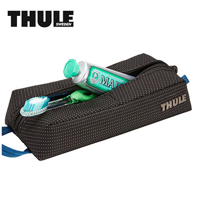 Thule Crossover 2 Travel Kit Pouch with toiletries and a toothbrush, perfect for organizing essentials.