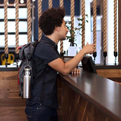 Man with Klean Kanteen Insulated Reflect Stainless Steel Bottle at a cafe counter, showcasing eco-friendly stylish design.