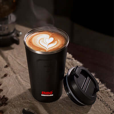 ENDO 500ML Double Stainless Steel Thermal Coffee Mug with latte art on a table, ideal corporate gift.