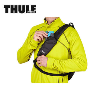 Man wearing Thule Legend Gopro Sling Pack with GoPro camera in pocket, showcasing convenience and style.