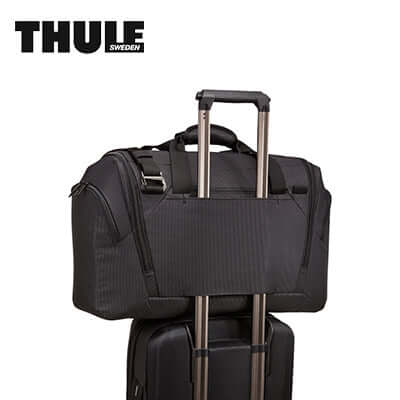 Thule Crossover 2 Duffel Bag 44L on top of rolling luggage for easy travel.