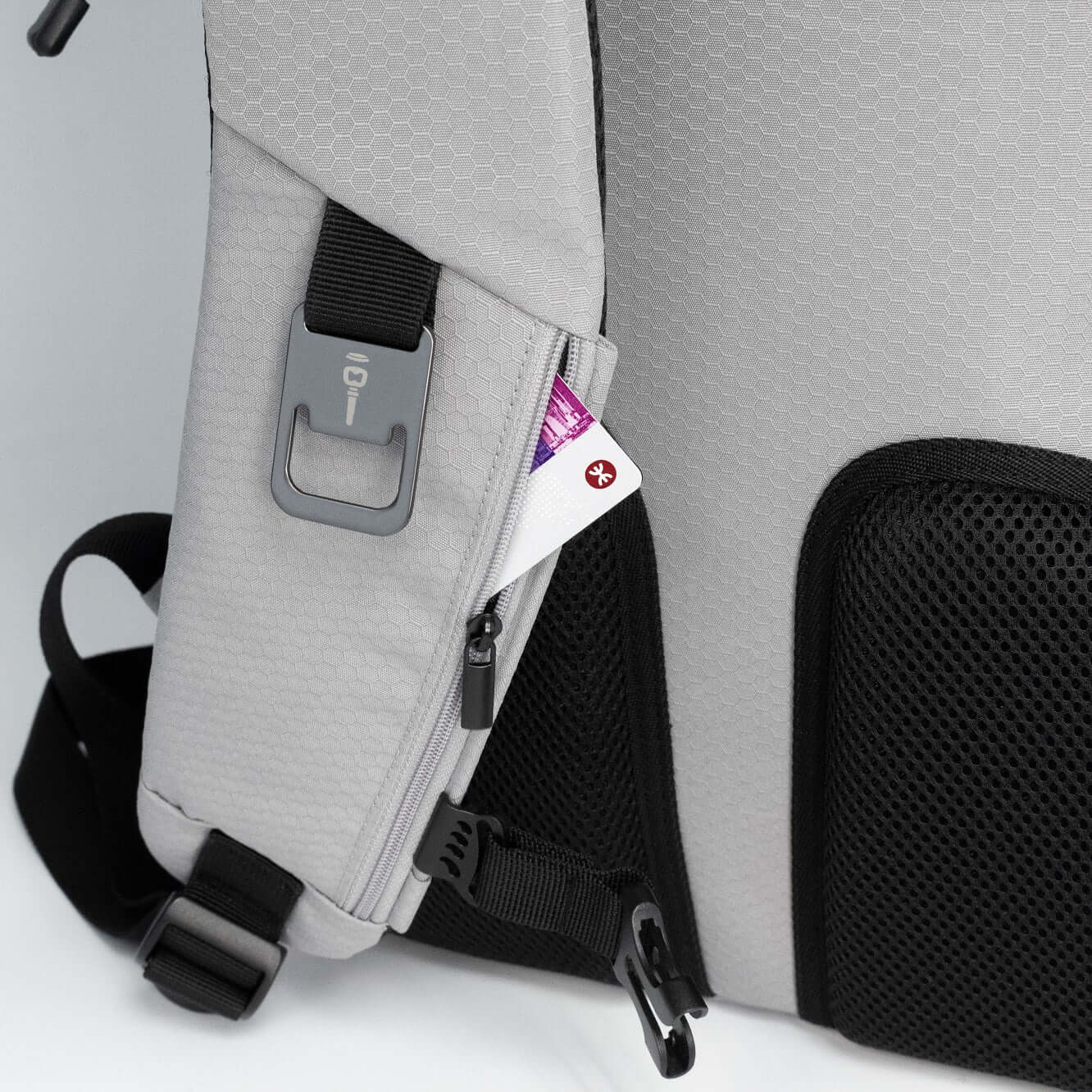 BrandCharger Nomad Eco Backpack featuring a side zipper compartment with essential items visible.