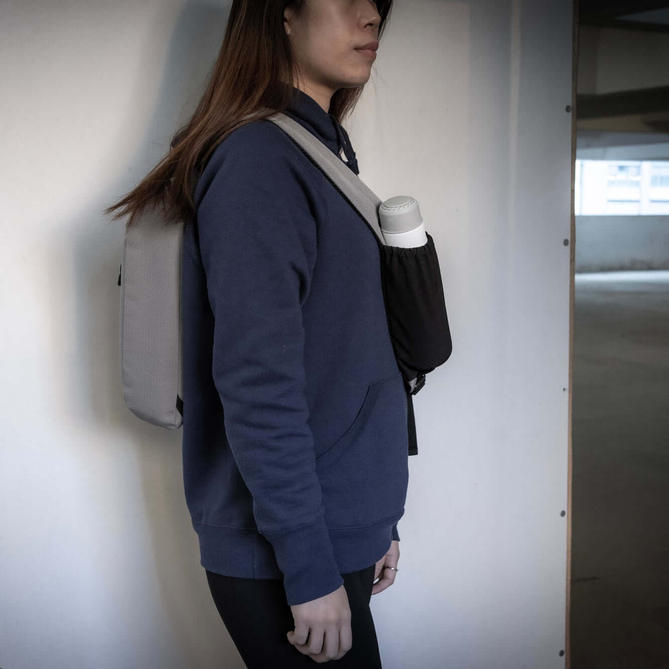 Woman wearing BrandCharger Eco Sling Bag as a shoulder bag with water bottle