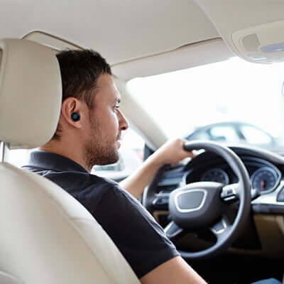 BrandCharger Talky Car USB Charger with Wireless Earpiece used by a man driving.