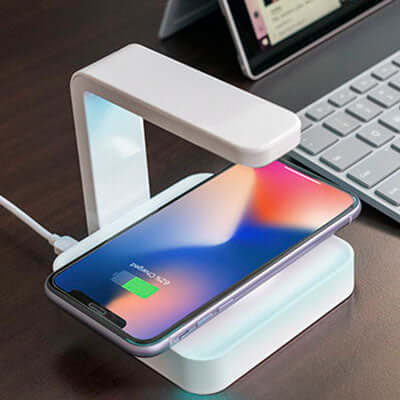 BrandCharger Apollo UV Sterilizer Wireless Charger charging a smartphone on a modern desk.