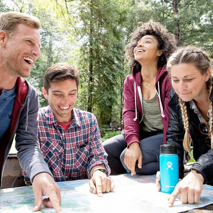 Group of friends enjoying outdoor adventure with HydroFlask 16 oz Coffee Flask on a map.