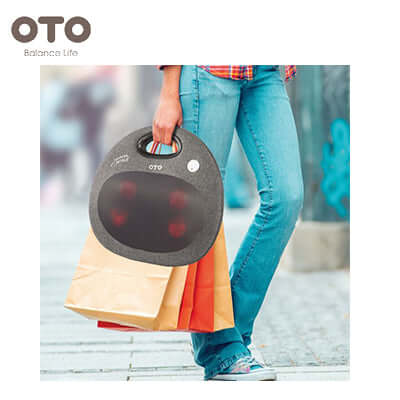 Person holding the OTO Handy Spa Oval back massager while shopping, perfect for corporate gift.