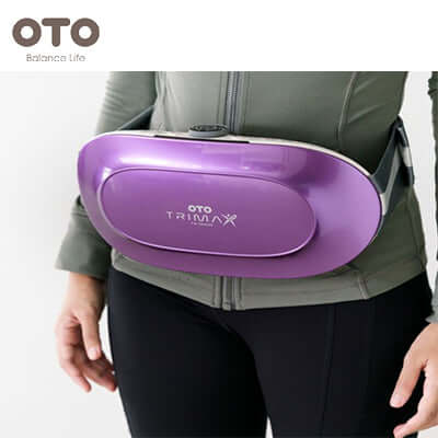 Woman using OTO Trimax Plus, a device for fat reduction and well-being, perfect for corporate gift.